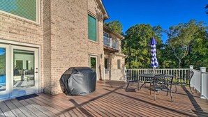 A wooden deck with outdoor furniture, a barbecue grill, and a covered patio area. - Luxe Lake Chickamauga Retreat w/ Boat Dock! (Harrison)