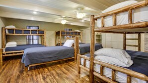 Een kamer met stapelbedden, houten vloeren en plafondventilatoren.