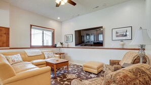 A living room with a beige sofa, a patterned armchair, a coffee table, and a rug. - Spacious Minneapolis Home Rental: 8 Mi to Downtown (Richfield)