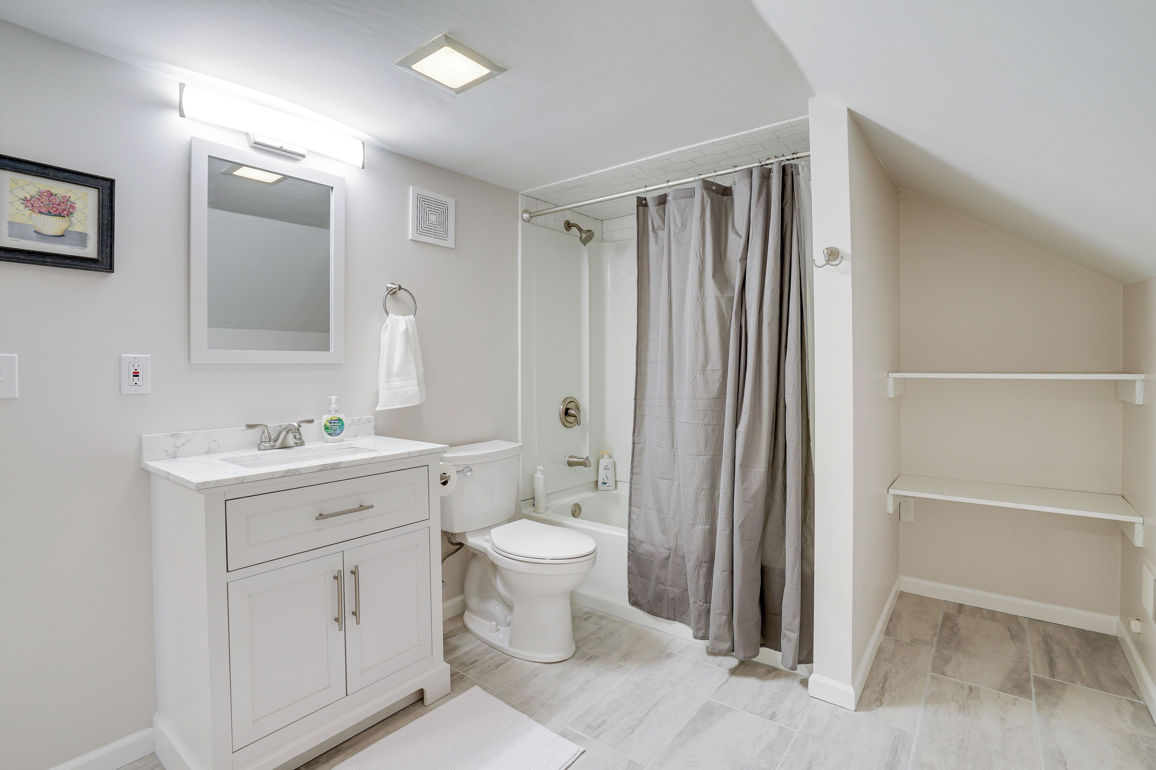 Un baño con inodoro, lavamanos y zona de ducha.