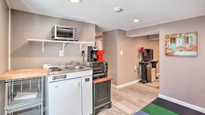 A compact kitchen with a microwave, toaster, and coffee maker on a shelf, a small refrigerator, and a sink. - Garden-level Millburn Apt - Walk to Transit! (Millburn)