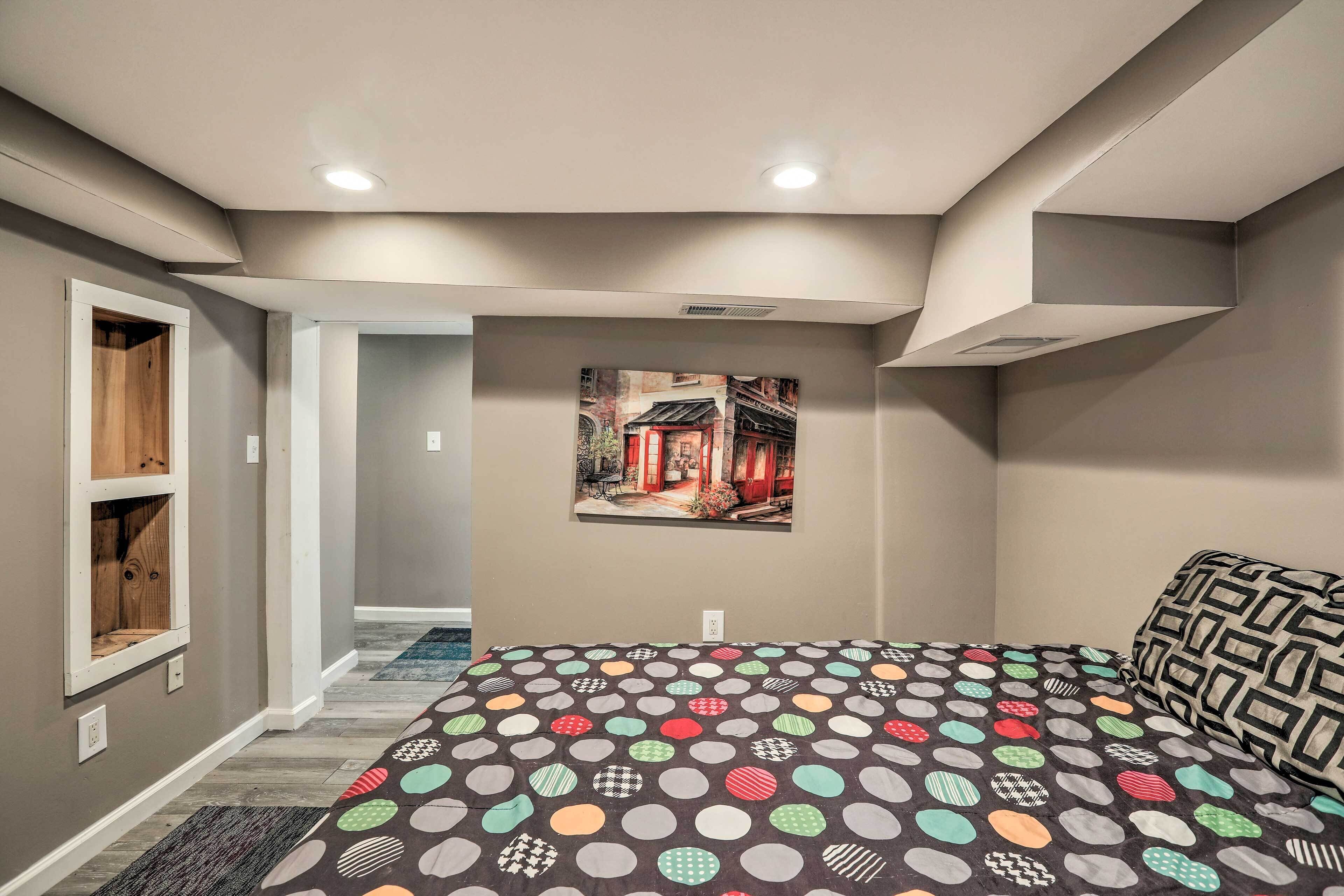 A bedroom with a bed, a wall-mounted picture, and a built-in shelf.