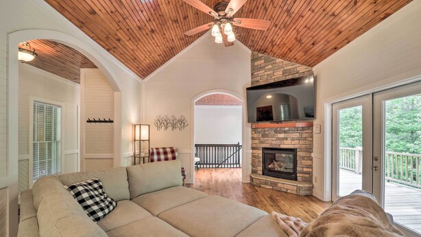 A spacious living room with a large sectional sofa, a stone fireplace, and a wooden ceiling. - Pond On-site! Dog-friendly Blue Ridge Mtn Retreat (Banner Elk)