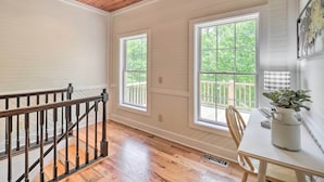 A room with a wooden ceiling, a staircase with a black railing, and large windows with a view of greenery outside. - Pond On-site! Dog-friendly Blue Ridge Mtn Retreat (Banner Elk)
