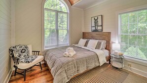 A bedroom with a large bed, a chair, a wooden ceiling fan, and a window with blinds. - Pond On-site! Dog-friendly Blue Ridge Mtn Retreat (Banner Elk)