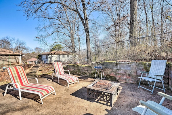 An outdoor patio area with two striped lounge chairs, a small table, and a grill. - Pet-friendly Birmingham Apartment w/ Patio! (Birmingham)