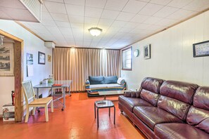 A living room with a sofa, a leather couch, a dining table, and a chair. - Pet-friendly Birmingham Apartment w/ Patio! (Birmingham)