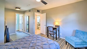 A hotel room with a bed, a desk, a chair, a blue sofa, a ceiling fan, and a bathroom visible through an open door. - Private Desert Retreat w/ Grill & Mtn Views! (Phoenix)