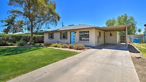 A single-story house with a front porch, a blue door, and a well-maintained lawn. - Private Desert Retreat w/ Grill & Mtn Views! (Phoenix)