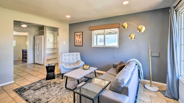 A living room with a sofa, armchair, coffee table, and floor lamp. There is a window with curtains and a picture on the wall. - Private Desert Retreat w/ Grill & Mtn Views! (Phoenix)