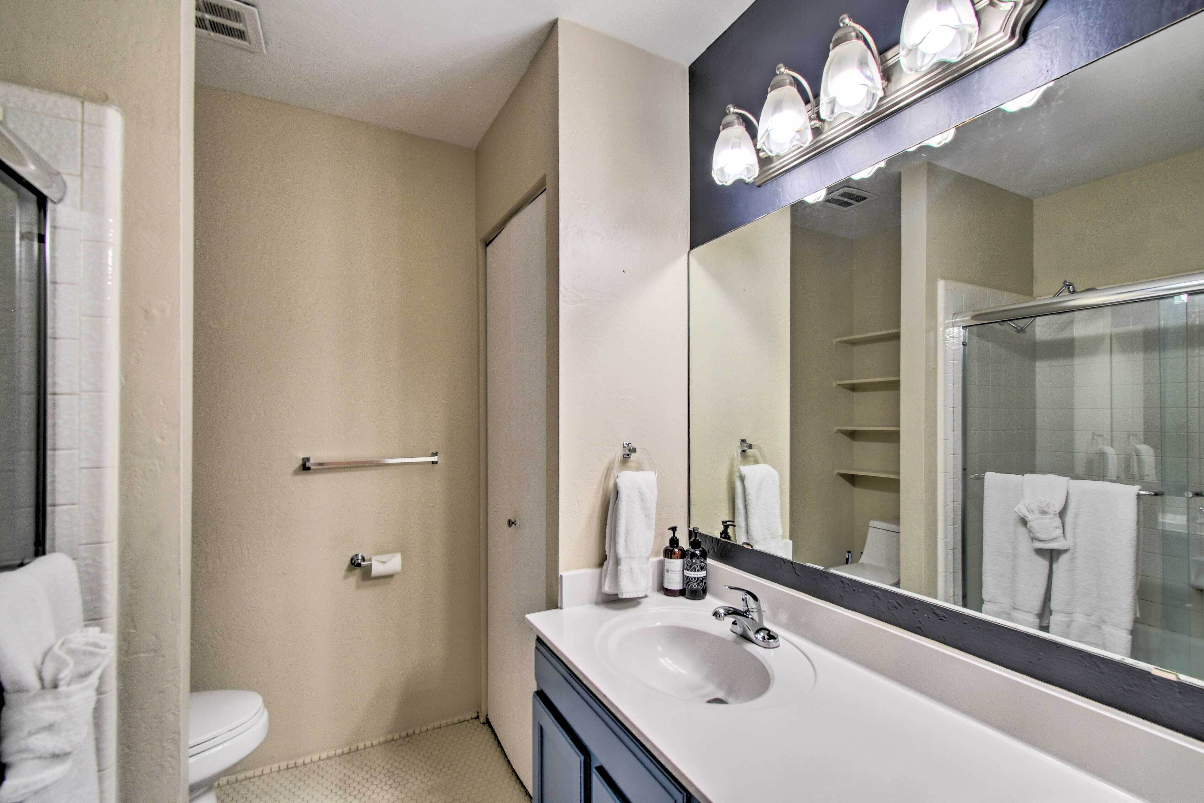 A bathroom with a white sink, a large mirror, and a shower area.