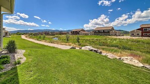 A residential area with houses, a grassy path, and a small body of water.