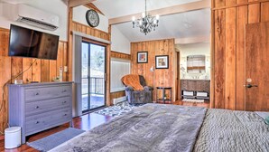 Une chambre spacieuse avec un grand lit, une commode, une chaise et un téléviseur.