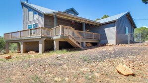A two-story house with a covered porch and a staircase leading to the upper level. - Secluded Show Low Home Near Hiking Trails! (Show Low)