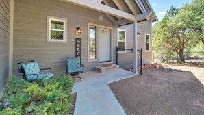A house with a covered porch, two chairs, a welcome sign, and a fenced yard. - Secluded Show Low Home Near Hiking Trails! (Show Low)