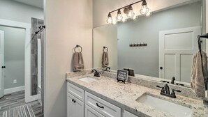 A bathroom with two sinks, a large mirror, and a towel rack. - All-encompassing Lakehouse w/ Modern Accents! (Edgemont)