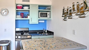 A compact kitchen with a stove, sink, and a microwave. - Surfside 'sandcastle Suite' w/ Balcony & 2 Pools! (Corpus Christi)