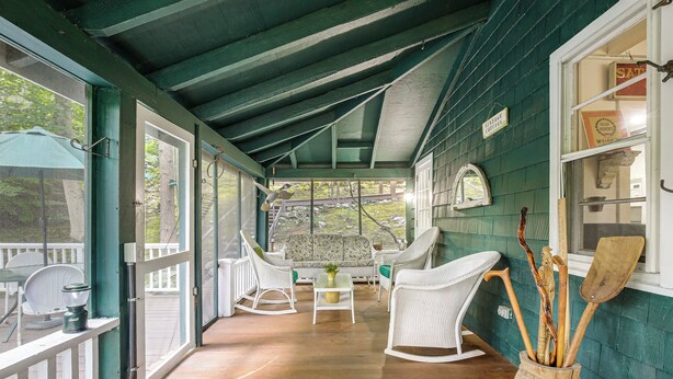 A covered porch with wicker furniture, a table, and a potted plant. - Dainty New Preston Cottage w/ Dock & Lake Views! (New Preston)