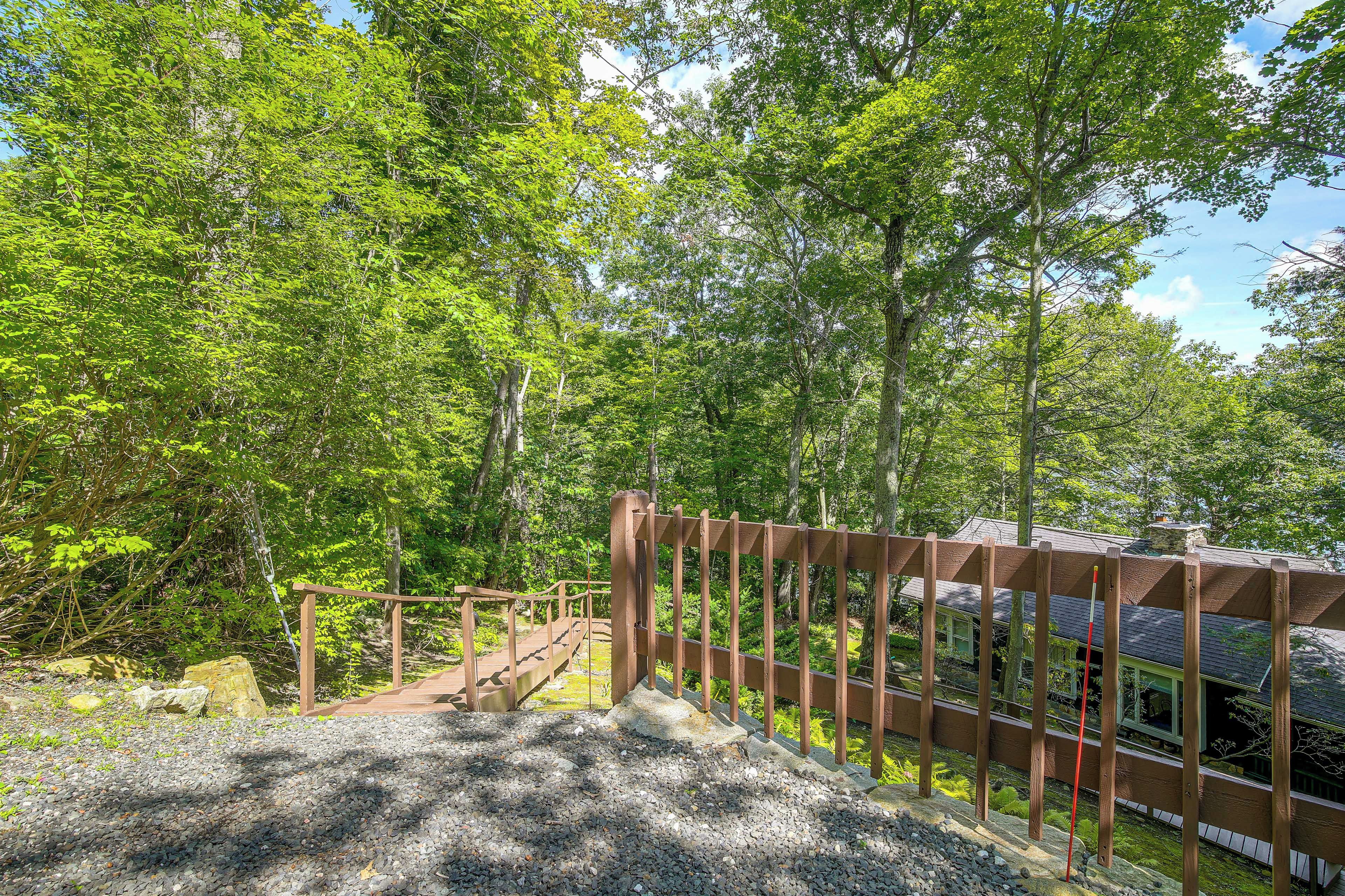 A wooden staircase leading up to a wooden fence with a house in the background.