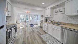 A modern kitchen with white cabinetry, a wooden countertop, and a built-in dishwasher. - Bright & Airy Liberty Lake Abode w/ Backyard! (Liberty Lake)