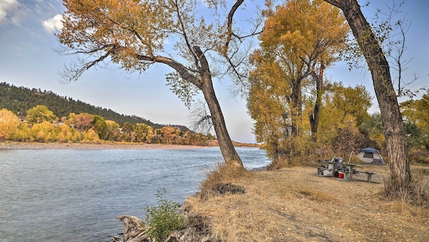 A riverside camping area with a tent and picnic table. - Charming Columbus Apt Along Yellowstone River (Columbus)