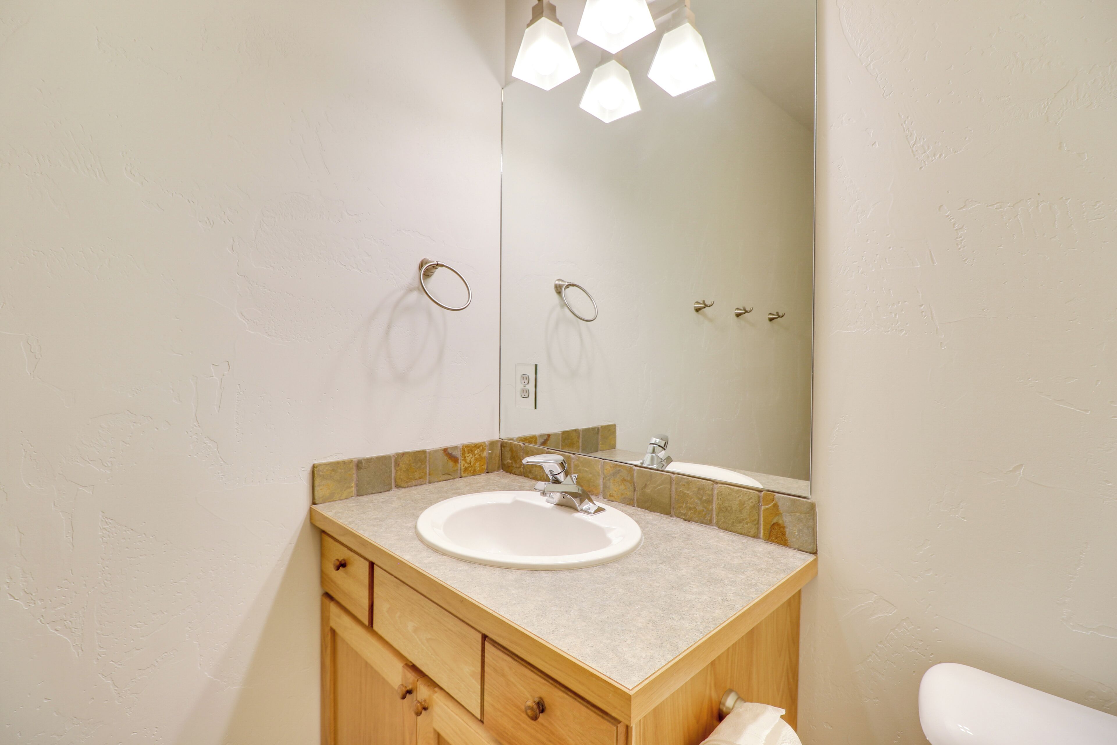 Une salle de bain équipée d’un lavabo, d’un miroir et d’un porte-serviettes.