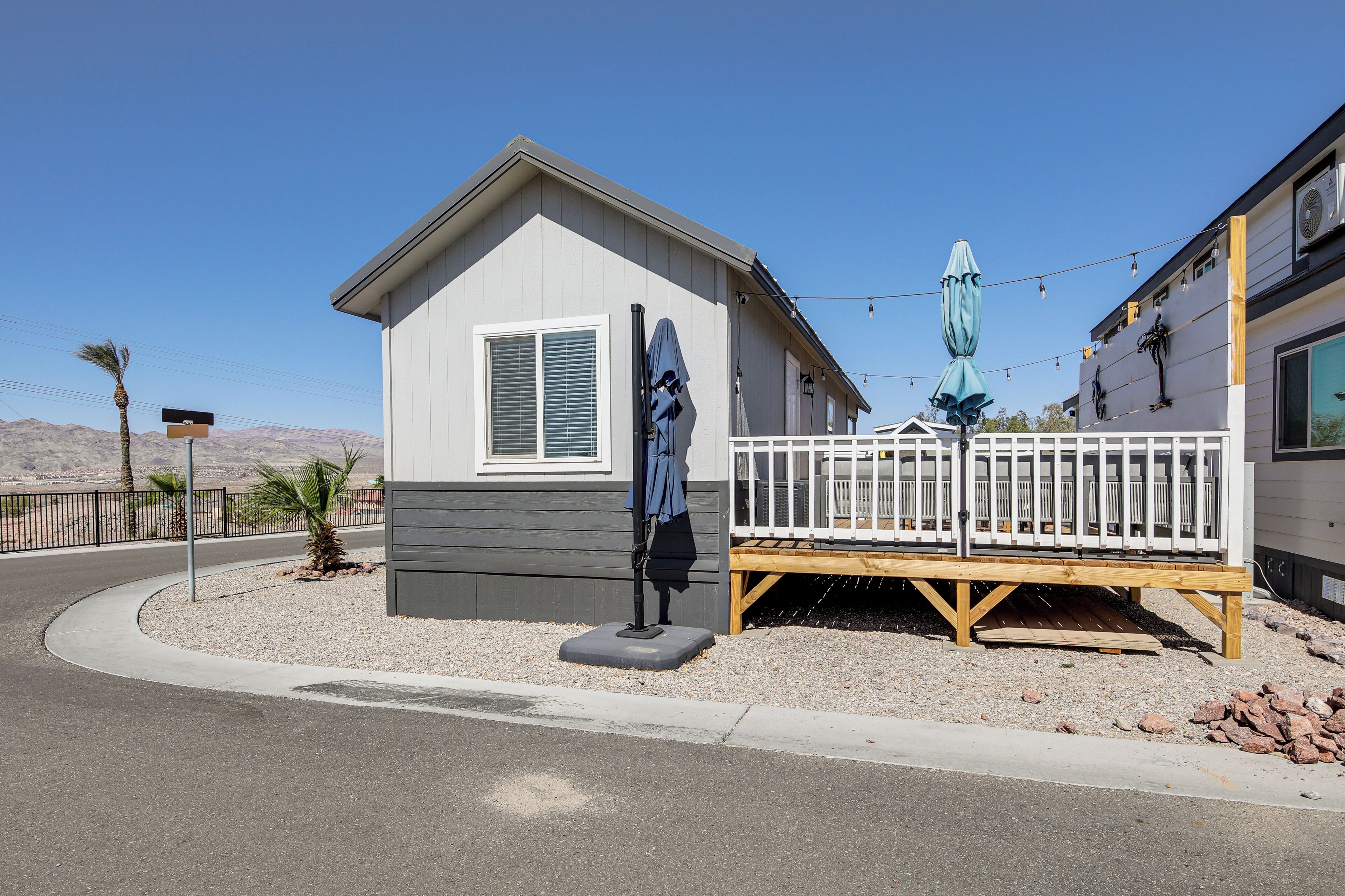 A small, single-story building with a white exterior and a wooden deck.