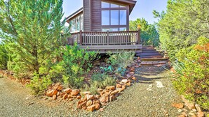 A modern cabin with a deck, surrounded by trees and a gravel path. - Mountain-view Deck: Bright Sedona Home (Sedona)