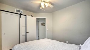 A bedroom with a bed, a ceiling fan, a door, and a hallway. - 2 Mi to Sports Complex: Peoria Home w/ Patio! (Peoria)