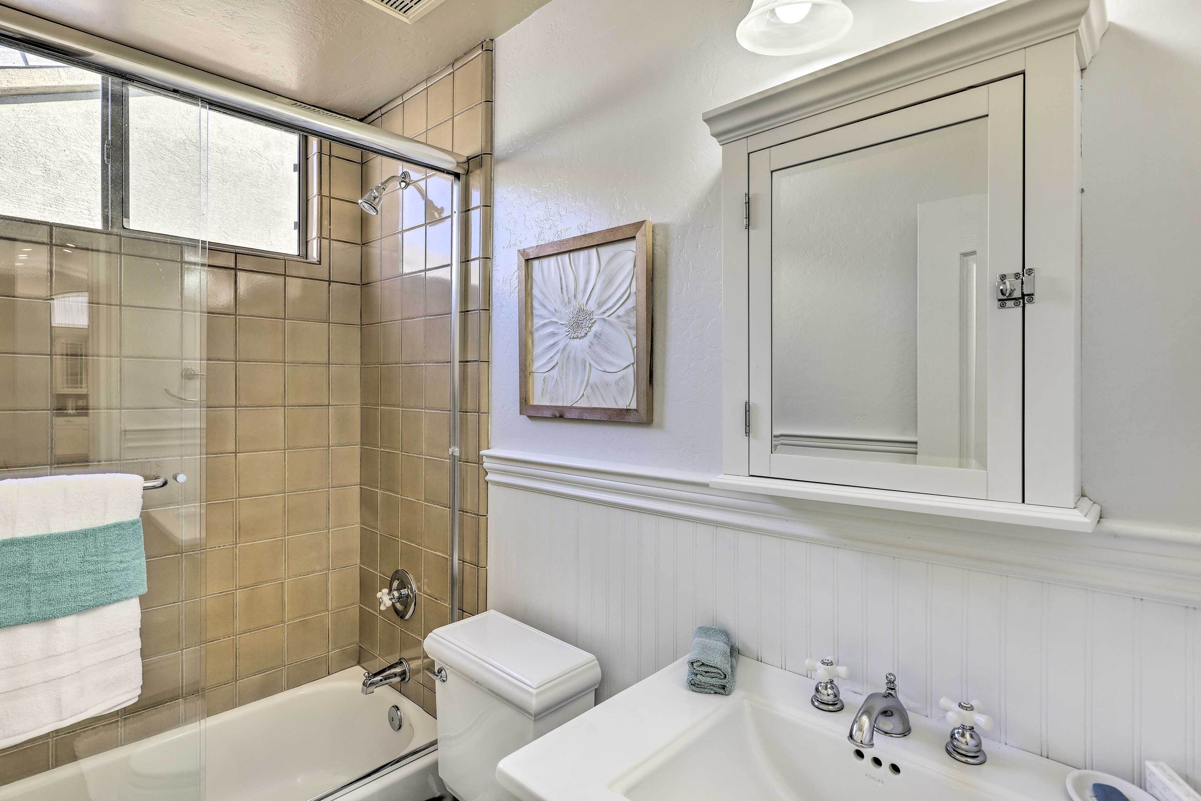 A bathroom with a bathtub, toilet, and sink.