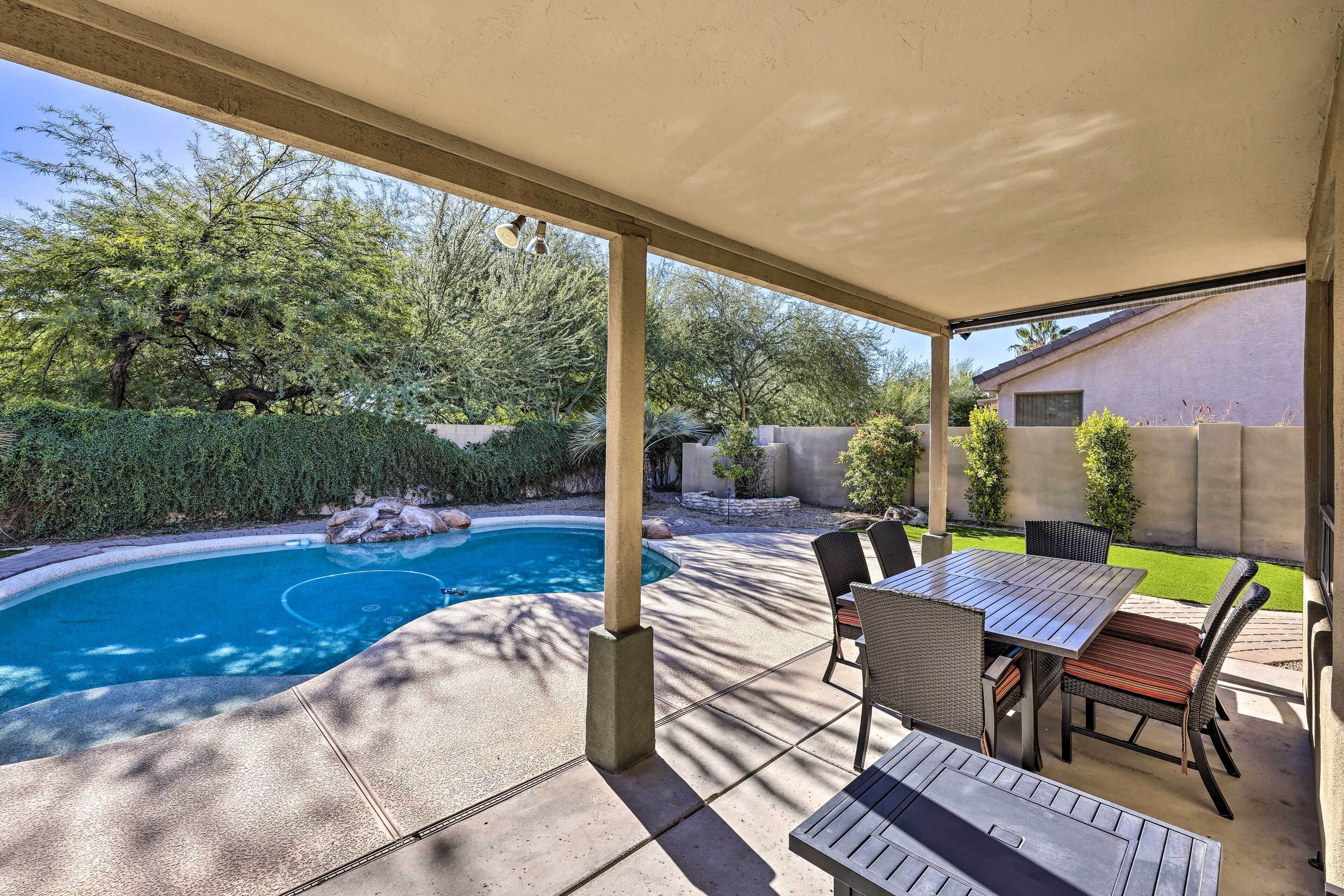Une terrasse couverte avec une piscine, du mobilier d  ’extérieur et une vue sur le jardin arrière.