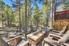 An outdoor patio with a stone fire pit, wooden chairs, and a table. - Flagstaff Hideaway: Private Hot Tub, 4 Mi to Dtwn! (Flagstaff)