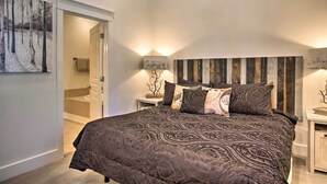 A bedroom with a large bed, a wooden headboard, and a painting on the wall. - Flagstaff Hideaway: Private Hot Tub, 4 Mi to Dtwn! (Flagstaff)