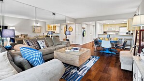 Ein modernes Wohnzimmer mit Sofa, Couchtisch und Essbereich.