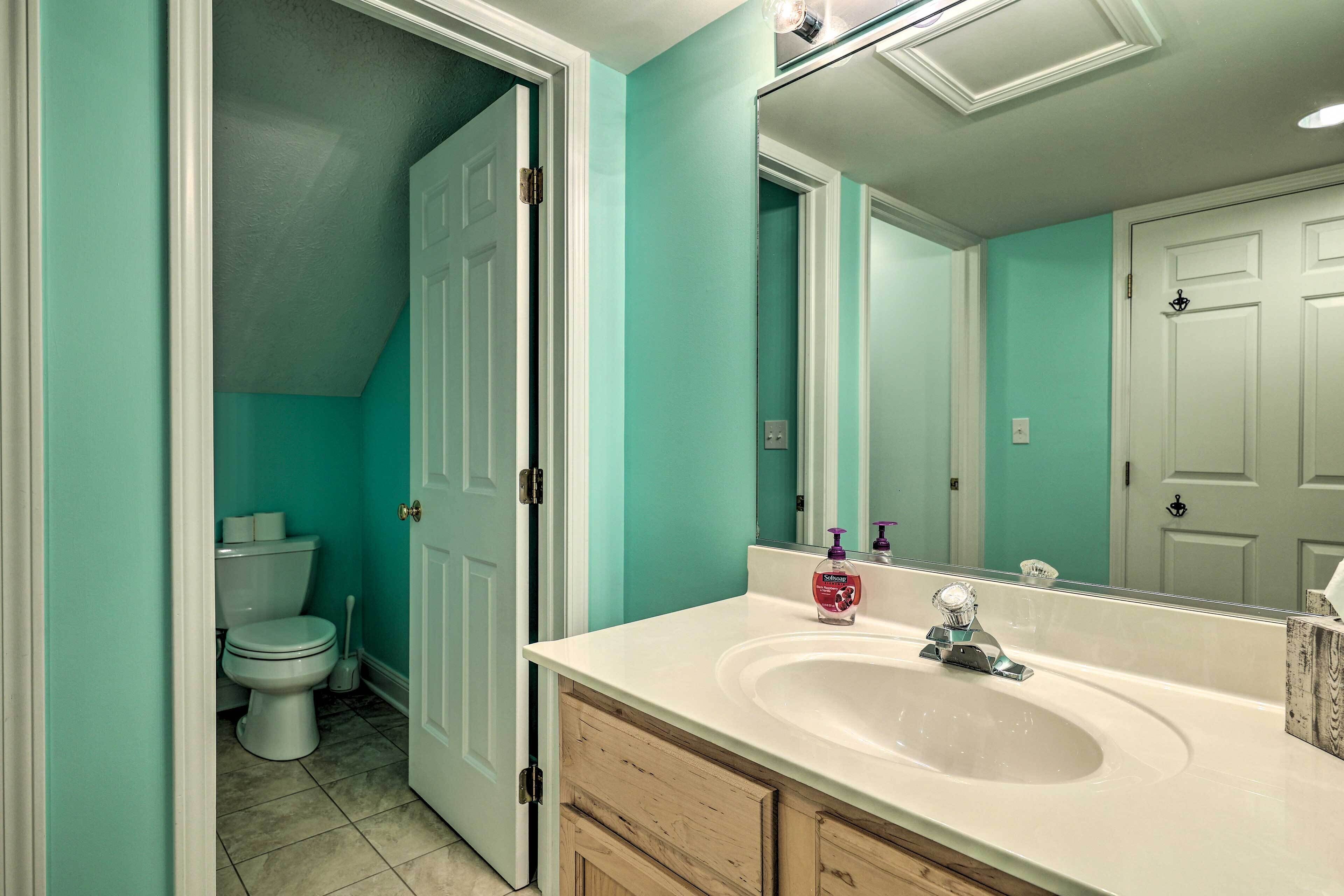 A bathroom with a white sink, a mirror, and a toilet.