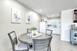 A modern dining area with a round table and chairs, a kitchen in the background, and artwork on the walls. - 2 Mi to Dtwn Gilbert! Snowbird Escape w/ Pool (Gilbert)