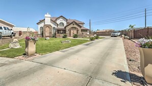 A residential house with a driveway, lawn, and a large planter with flowers. - 2 Mi to Dtwn Gilbert! Snowbird Escape w/ Pool (Gilbert)