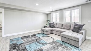 A modern living room with a sectional sofa, a patterned rug, and a window with blinds. - 2 Mi to Dtwn Gilbert! Snowbird Escape w/ Pool (Gilbert)