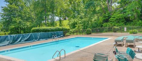 A rectangular swimming pool with a tiled edge, surrounded by a gravel deck. There are metal ladders on the pool's short side.