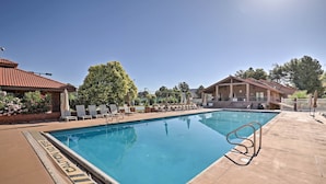 A swimming pool with lounge chairs and a covered area, surrounded by trees and buildings. - 5 Mi to Town Square Park: Condo in Sports Village (St. George)