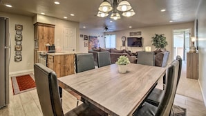 A modern kitchen with a dining area, wooden cabinets, and a large chandelier. - 5 Mi to Town Square Park: Condo in Sports Village (St. George)