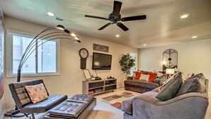 A living room with a ceiling fan, a flat-screen TV, a sofa, a loveseat, and a coffee table. - 5 Mi to Town Square Park: Condo in Sports Village (St. George)