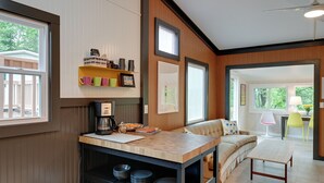 Une cuisine moderne dotée d’un plan de travail en bois, d’une machine à café et d’un coin repas avec une table et des chaises.