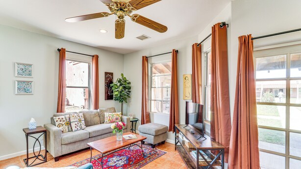 A living room with a sofa, coffee table, TV, and a ceiling fan. - Arizona Desert Vacation Rental w/ Pool Access! (Eloy)