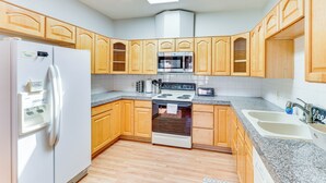 A kitchen with wooden cabinets, a stainless steel refrigerator, a microwave, an oven, and a sink. - Arizona Desert Vacation Rental w/ Pool Access! (Eloy)
