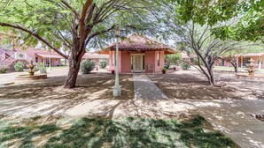 A building with a tiled roof, a central entrance, and a paved pathway leading to it. - Arizona Desert Vacation Rental w/ Pool Access! (Eloy)