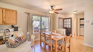 A dining area with a wooden table and chairs, a ceiling fan, and a view through a window. - 'the Crooked Pot Cabin' Near Hiking + Dining! (Pine)
