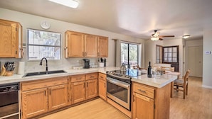 A modern kitchen with wooden cabinets, stainless steel appliances, and a large island. - 'the Crooked Pot Cabin' Near Hiking + Dining! (Pine)