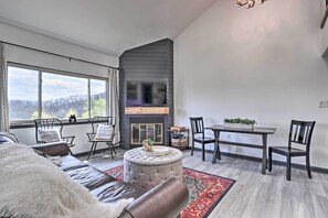 Una sala de estar moderna con chimenea, un sofá, una mesa de comedor y sillas.