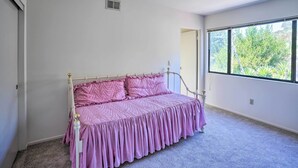 Quarto com cama, janela e porta.